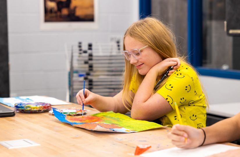 student painting in art class